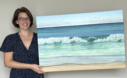 Artist holding a painting of a beautiful green ocean wave